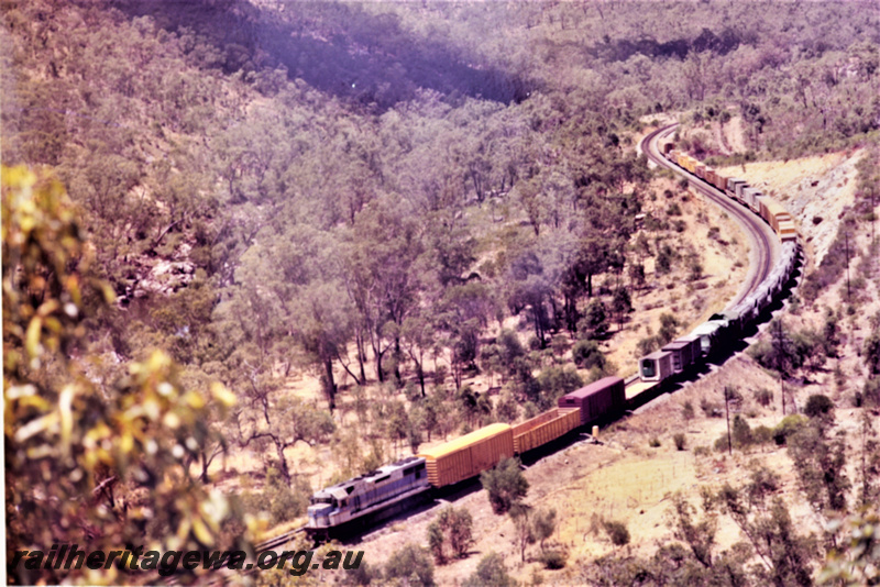 P22217
Standard gauge diesel on freight train including 7 WN class nickel wagons, Avon Valley line, front and side view from elevated position
