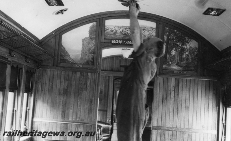 P22225
Interior view of AYL class lounge car, showing worker adjusting overhead fan, and scenic pictures on compartment divider
