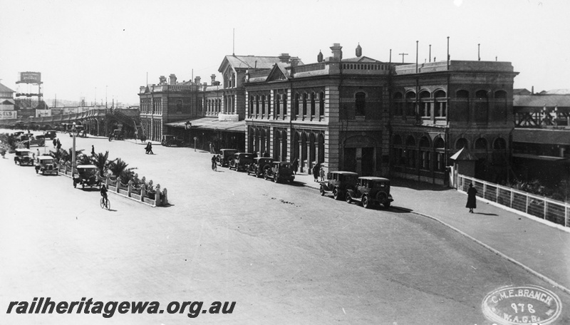 P22242
View of Perth railway station, faade, horseshoe bridge, water tower, concourse, parking area, motor vehicles, passers-by, view along the faade looking towards the horseshoe bridge
