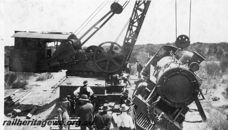 P22263
Derailment at 169 mile near Bruce Rock YB line No 6 of 7, Cravens 25 ton breakdown crane No.23, lifting L class 240, onlookers, front view of loco
