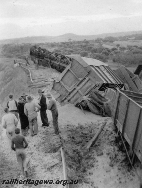 P22266
Bringo Crash 1 of 2, loco upended, wagons derailed, track torn up, group of onlookers including driver J. Larcombe, fireman E. Gleed, guard N. Criddle, Bringo, NR line, view from track level looking towards front of train
