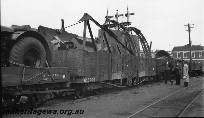 P22337
H class wagon 1246 loaded with tractor, RA class wagon 5704 with 5 plank sides loaded with steel framework, other wagons, onlookers, triple semaphore signal, end and side view from trackside
