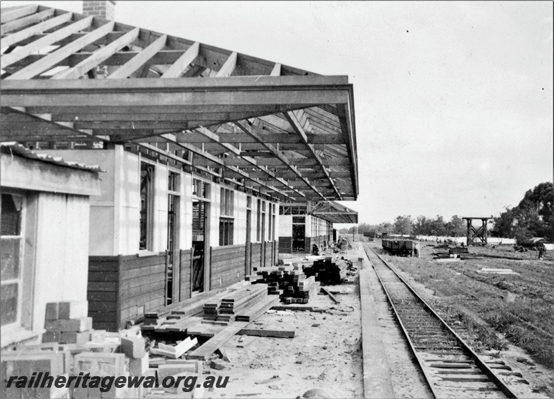 P22369
Construction of station building at Brunswick Junction SWR line 2 of 4, partly completed roofs and buildings, platform, bricks, timber, wagons, workers, tank stand, view along platform
