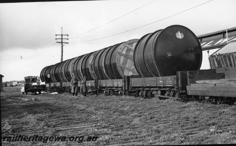 P22381
Loading of vats for Merredin Brewery at Fremantle ER line 3 of 4, H class 2789 wagon loaded with two vats, other wagons also loaded with vats, truck, workers, shed, side and end view from trackside 

