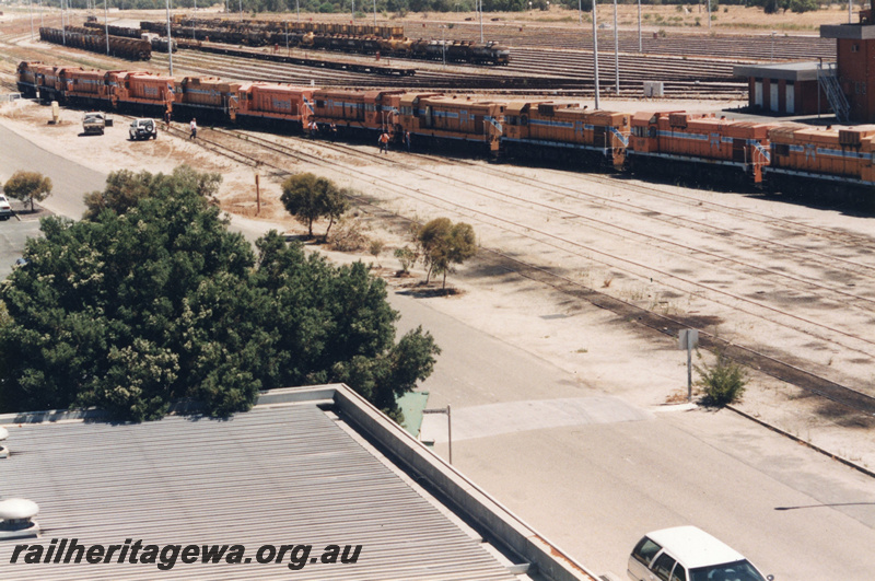 P22401
Ten diesel locomotives lashed up, control tower, sidings, rakes of wagons, onlookers, Forrestfield marshalling yard, side and end views from elevated position  
