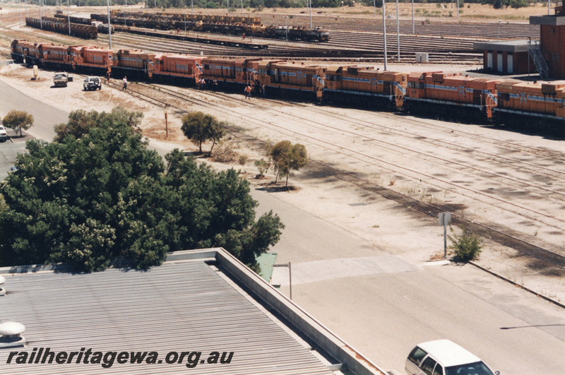 P22401
Ten diesel locomotives lashed up, control tower, sidings, rakes of wagons, onlookers, Forrestfield marshalling yard, side and end views from elevated position  
