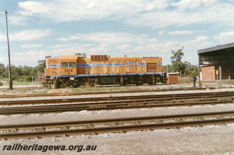 P22462
A class 1512, in Westrail orange livery with blue and white stripe, shed, tracks, side view
