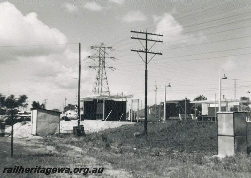 P22473
Oats Street station SWR line 1 of 5, shelters, shelter under construction, work shed, power pylon, telegraph pole, view from ground level adjacent to station, c1976-1977
