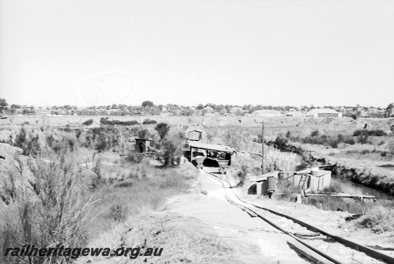 P22483
Australian Railway Historical Society Western Australian Division tour to Maylands brickworks 6 of 16, overview of site, wagons, sheds, tracks, points, watercourse, view from trackside 
