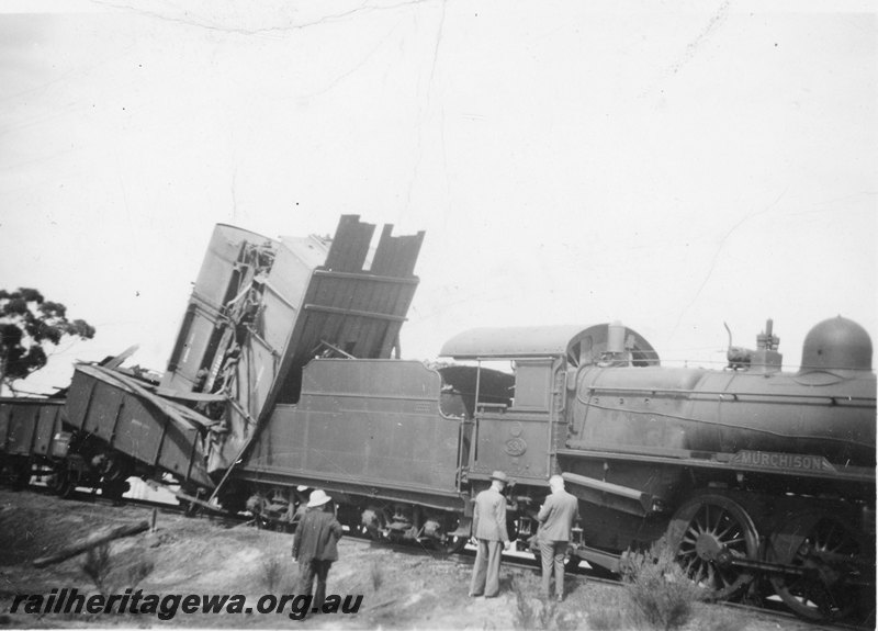 P22566
Head on collision of PR class 530 and PR class 531 on No W7 Water Train and No 76 Goods near Botherling EM line on 20 April 1950 No 4 of 7, PR class 530, derailed wagons, railway officials inspecting damage, side and front view (part) from trackside
