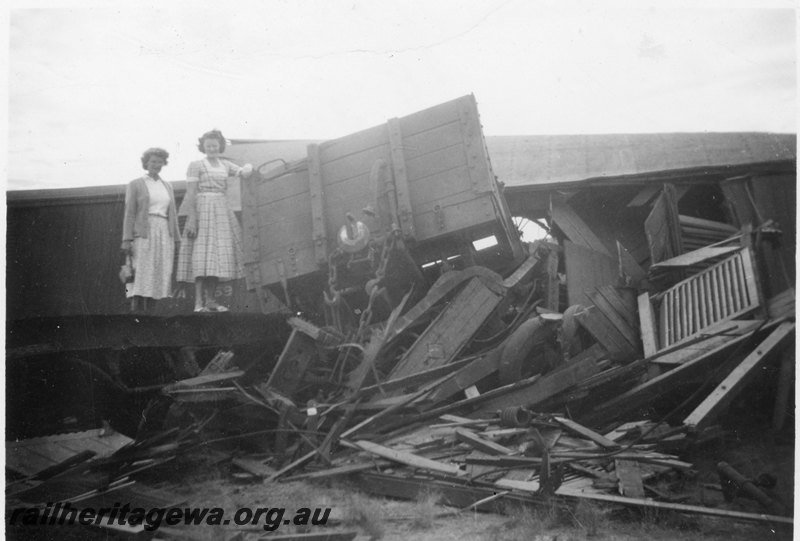 P22568
Head on collision of PR class 530 and PR class 531 on No W7 Water Train and No 76 Goods near Botherling EM line on 20 April 1950 No 6 of 7, wrecked wagons, Sonia and Barbara Whisfield standing on wreckage, view from track level
