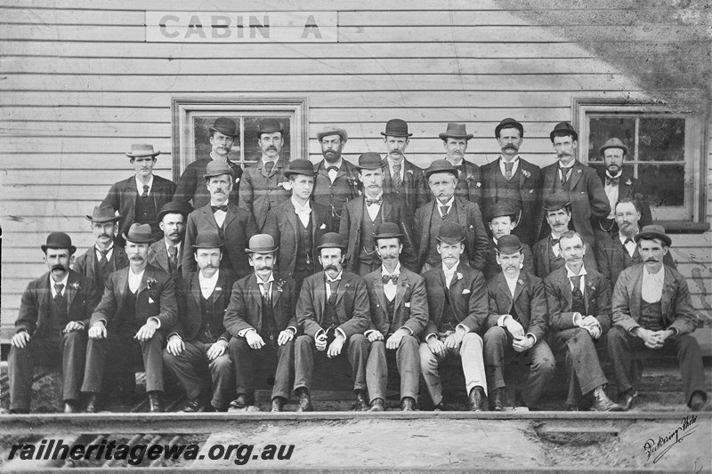 P22575
Group photo of 28 men in suits and hats, in front of Cabin A, c1940s

