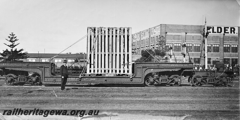 P22579
QX class 2300 trolley wagon loaded with vertical pallet, JD class tank wagon in Shell livery, onlooker, signal, Elders building, Fremantle, ER line,side view.

