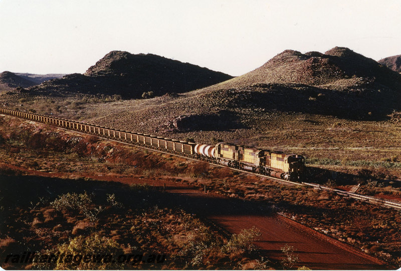 P22587
Cliffs Robe River Iron Associates locomotives 9410, 9422, 9416 triple heading down iron ore train, 15 km, Pilbara, side and front view
