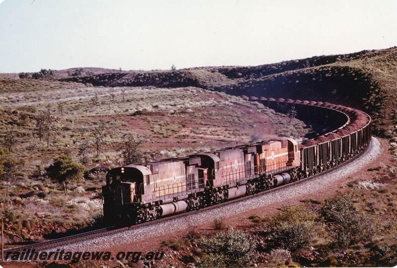 P22588
Mount Newman Mining locomotives 72, 91 and 83 triple heading up iron ore train, 213.2km level crossing, Pilbara, front and side view
