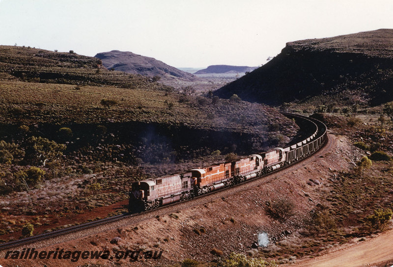 P22590
Mount Newman Mining locomotives 98, 56, 52 and 73, quadruple heading empty iron ore train, 211 km, Pilbara, front and side view
