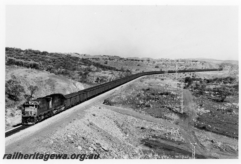 P22594
Hamersley Iron locomotives 4051 and 3010 on up iron ore train with 4032 and 4047 on rear, 327 km, Pilbara, front and side view
