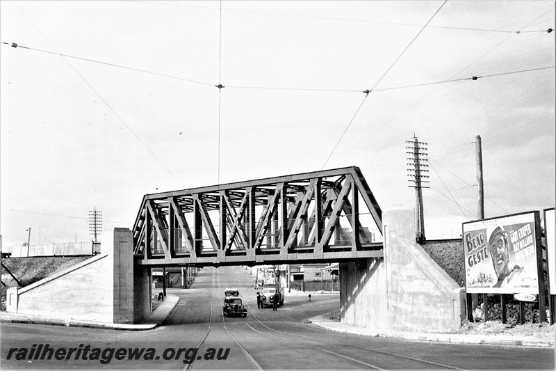P22763
Extension of Mt Lawley subway ER line No 12 of 15, truss bridge, subway, advertising hoarding, gasometer, overhead tram wires, cars, view looking east

