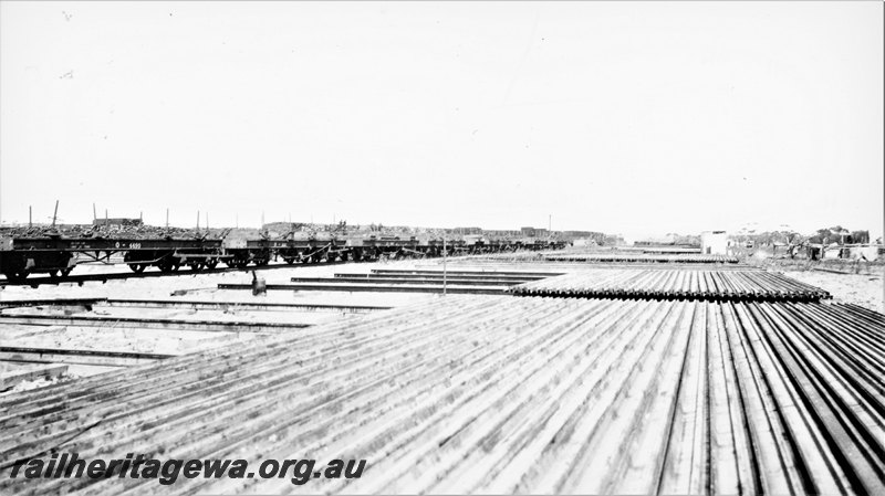 P22771
Q class 4490 flat wagon, other Q class wagons, in yard, trackside buildings, overview
