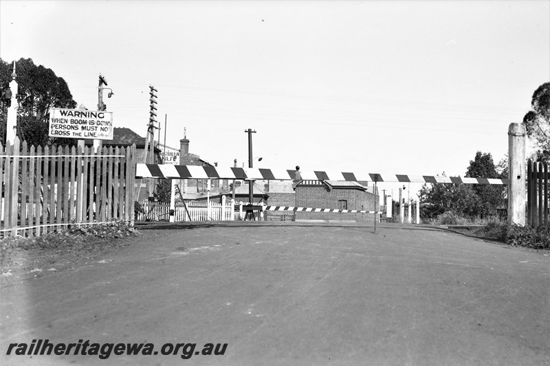 P22774
Pedestrian crossing, boom gates lowered, signals, warning sign, buildings, Claremont, ER line, view looking across tracks
