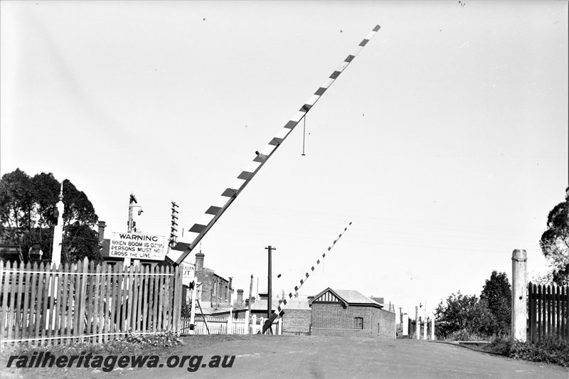 P22775
Pedestrian crossing, boom gates raised, signals, warning sign, buildings, Claremont, ER line, view looking across tracks
