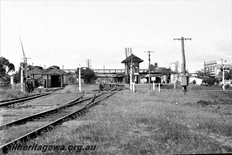 P22776
Station, platforms, station buildings, signal box, goods shed, signals, level crossing, pedestrian overpass, tracks, points, Claremont, ER line, view from track level looking through station towards Perth
