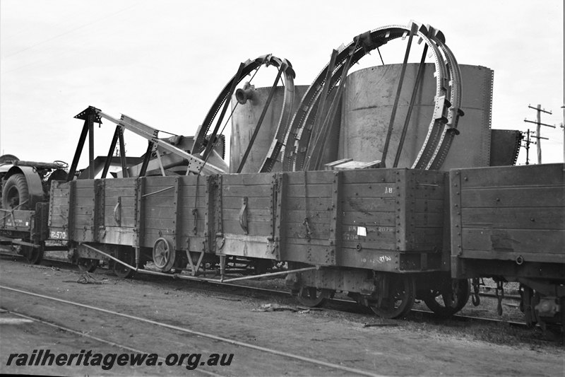 P22778
RA class 5704 5 plank wagon loaded with water tanks and fixings 2 of 4, other wagons (part), Fremantle, ER line, side and end view from trackside
