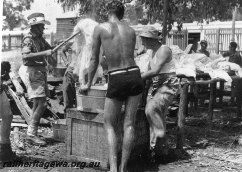 P22788
Washing sheets trackside, army ambulance train 10 AAT, soldiers, train in background, ground level view
