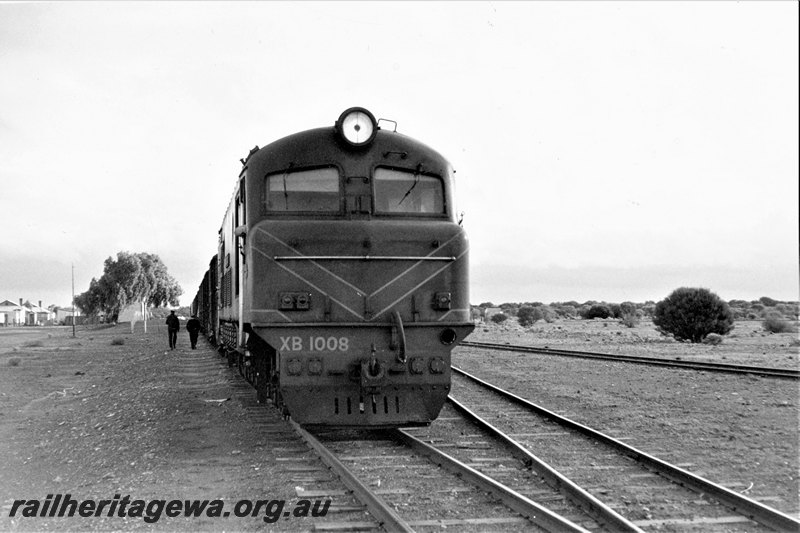 P22812
XB class 1008, on northbound No 191 goods, trackside buildings, 2 workers, siding, Kookynie, KL line, side and front view 
