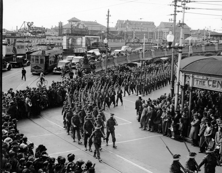 P22945
Street parade, troops marching from Perth station into William Street, tram 23, cars, horseshoe bridge, crowded footpaths, Perth, ER line, elevated view
