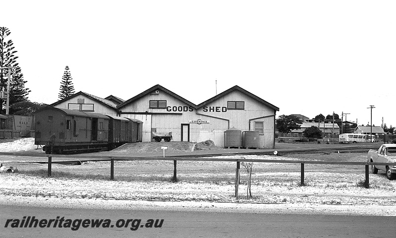 P24263
Goods shed 1st class, vans, platform, car, bus, Norfolk Island pines, Esperance, CE line, view from road level 
