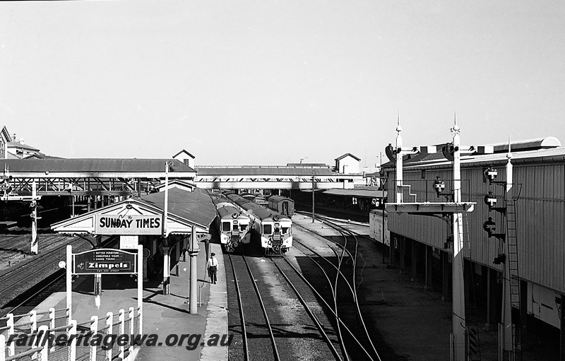 P24266
Diesel multiple units, platforms, canopies, rail official, bracket signals, pedestrian ramp, overhead footbridge, sidings, Perth city station, elevated view from overhead bridge
