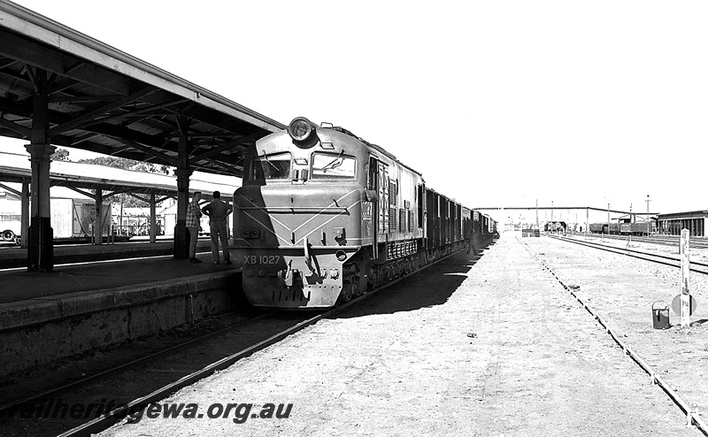 P24280
XB class 1027, on mixed train to Leonora, at station, platforms, canopies, rail employees, pedestrian overpass, Kalgoorlie, KL line, front and side view
