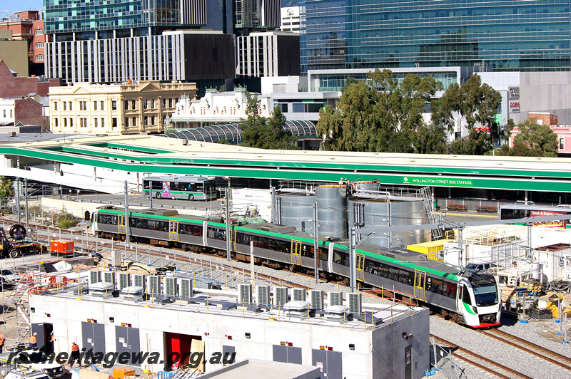 P24320
EMU set 56 comprising BEA, BEB and BET class railcars, Wellington Street bus station and city buildings in background, Perth, Joondalup line, side and end view
