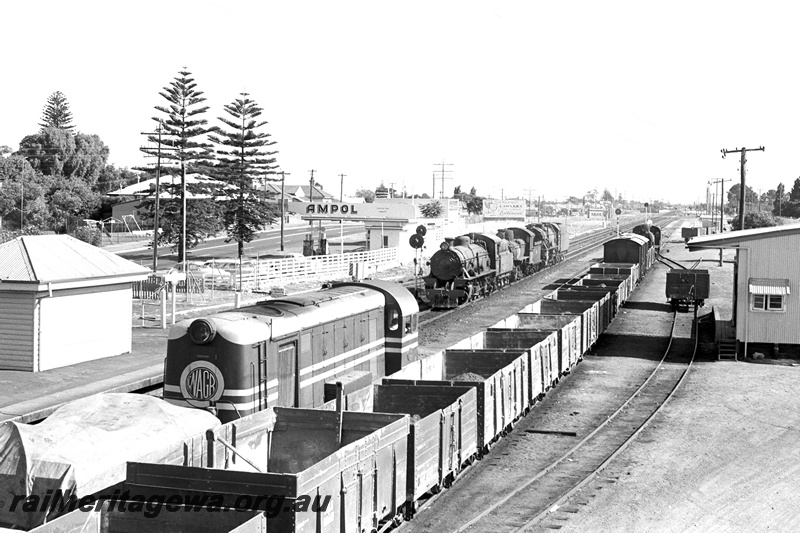 P24358
F class diesel loco on covered wagon, W class 903, F class 417, V class 1216 light engine to Midland, U class loco shunting van and open wagons, station building, platform, goods shed 4th class, Ampol garage, Norfolk Island palms, Bassendean, ER line, front and side view

