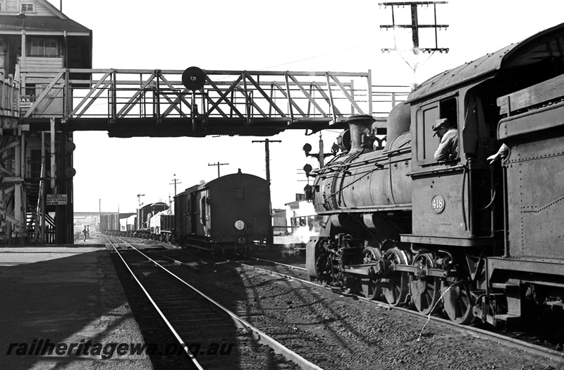 P24382
FS class 418, pushing No 35 Goods to Bunbury out of East Perth, rake of wagons, overhead footbridge, platform, signal box, signal, SWR line, side and rear view
