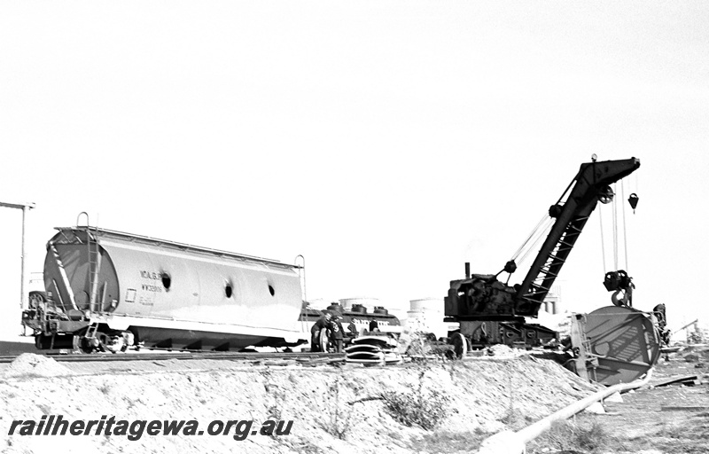 P24386
Breakdown crane No 31, lifting derailed WW class grain wagon lying on its side, another derailed WW class grain wagon, onlookers, workers, tanker wagons, Leighton yard, ER line, view from ground level
