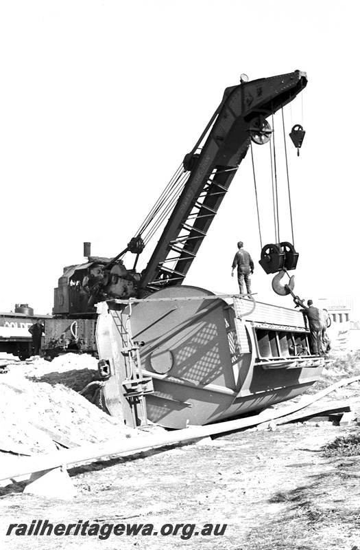 P24387
Breakdown crane No 31, lifting derailed WW class grain wagon lying on its side, workers, tanker wagons, Leighton yard, ER line, view from trackside
