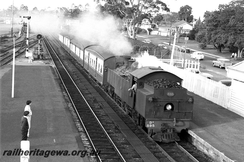 P24391
DD class 595, running tender first, on suburban passenger service, entering station, platforms, passengers, semaphore signal, light signal, Claremont, ER line, side and front view from elevated position
