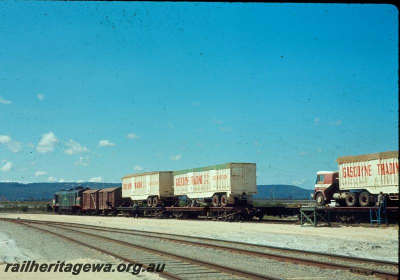 T00499
Gascoyne Traders Semi trailer trucks loaded onto QCP class bogie flat wagons, Kewdale yard, one of the wagons painted  in the black livery

