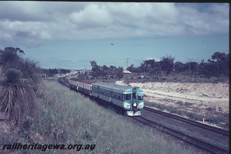 T02432
ADX class 670, Nanking blue and light grey livery, stainless steel cowcatcher, white tail disc, trailing car on a three car railcar set, approaching Karrakatta on a Fremantle bound suburban service, view along the train. ADX 670 ran in this livery from 7.7.1966 to 22.10.1968
