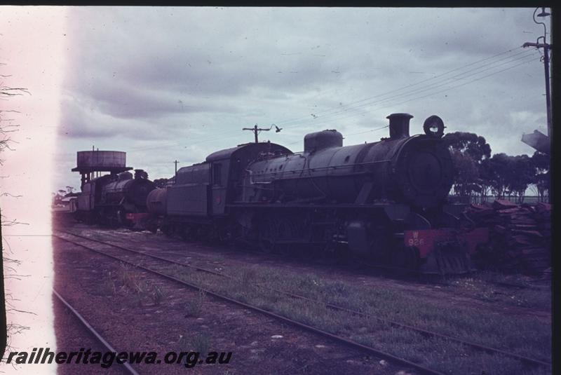 T02467
W class 926, W class 958 separated by a J class water tank wagon, Water tower with a round tank, loco depot, Lake Grace, WLG line, side and front view
