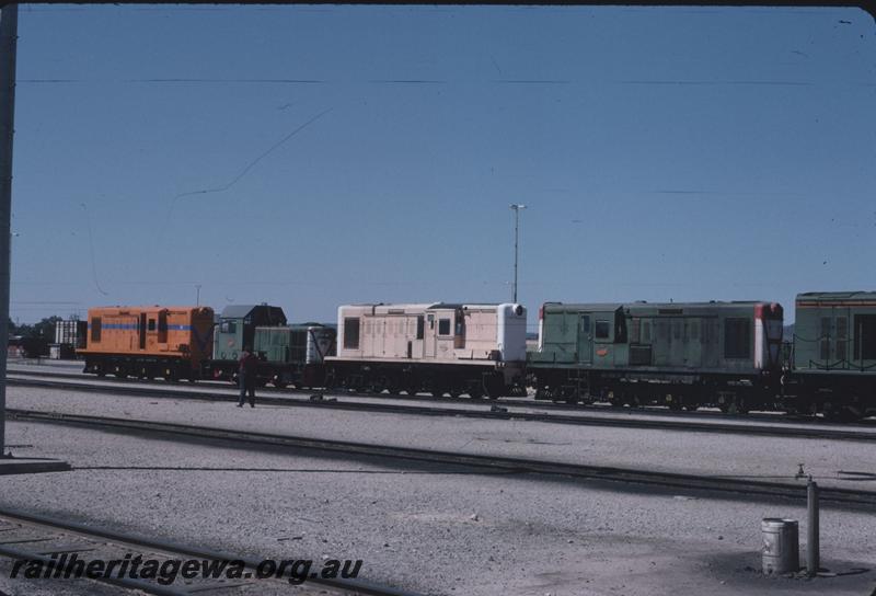 T02787
Y classes and a B class lined up at Forrestfield Yard, Left to right, Y class 1115 in Westrail orange livery but without the white pinstriping, B class 1605, Y class 1110 in pink livery with white ends and Y class 1111 in green livery, side and front views.
