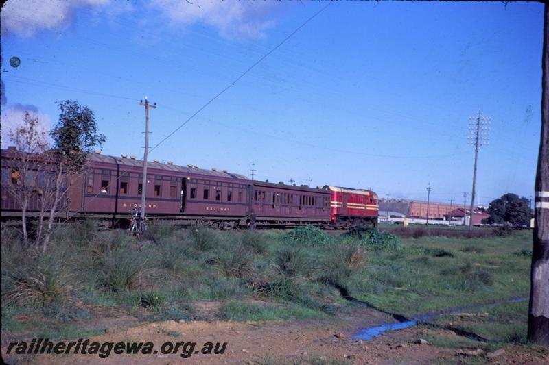 T03505
MRWA F class, arriving at Midland with passenger train, shows JV class carriage with blue stripe on side under the windows.
