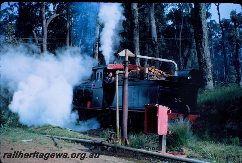 T03564
Bunnings loco YX class 86, water column, taking water, rear view.
