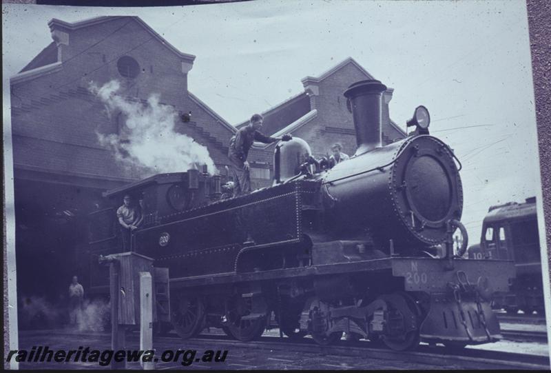T03966
N class 200 4-4-4T steam locomotive, being prepared for the ARHS outing Perth-Armadale-Jandakot-Fremantle-Perth on the 27th of June 1960, , East Perth loco depot, side and front view, fire hydrant and hose box in the foreground.
