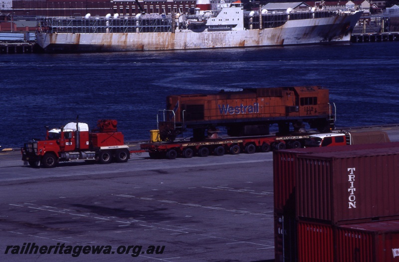 T04346
1 of 2, AA class 1518 diesel locomotive in Westrail orange livery on low loader, Fremantle wharf, bound for NZ.
