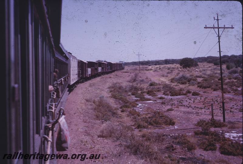 T04350
Mixed goods train, water bag suspended from carriage in foreground, telegraph poles, scrub, photo taken from rear of train, regional line
