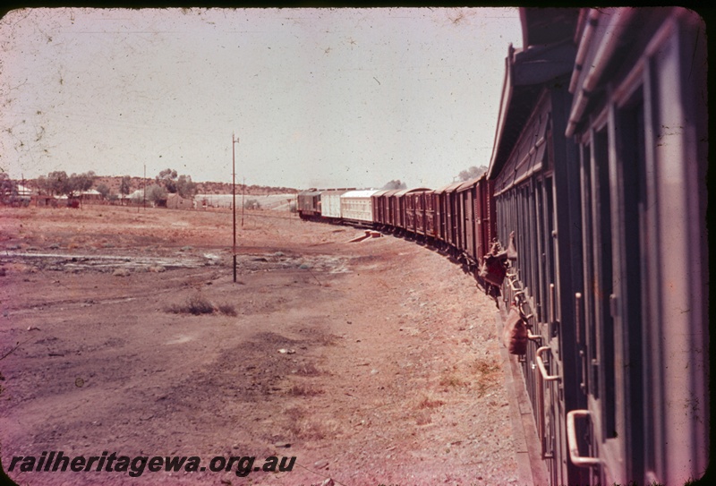 T04362
Mixed goods train, water bags suspended from carriages, telegraph poles, scrub, photo taken from rear of train, regional line
