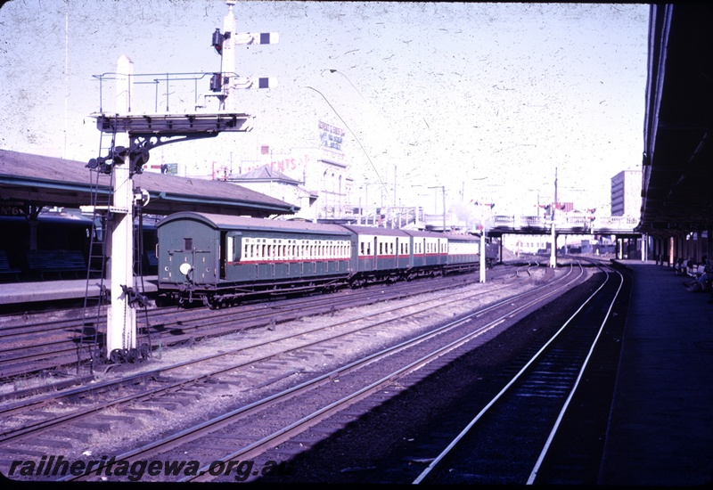 T04364
Bracket signal, multiple tracks, three green and cream passenger carriages, overhead bridge in the distance, Perth Station
